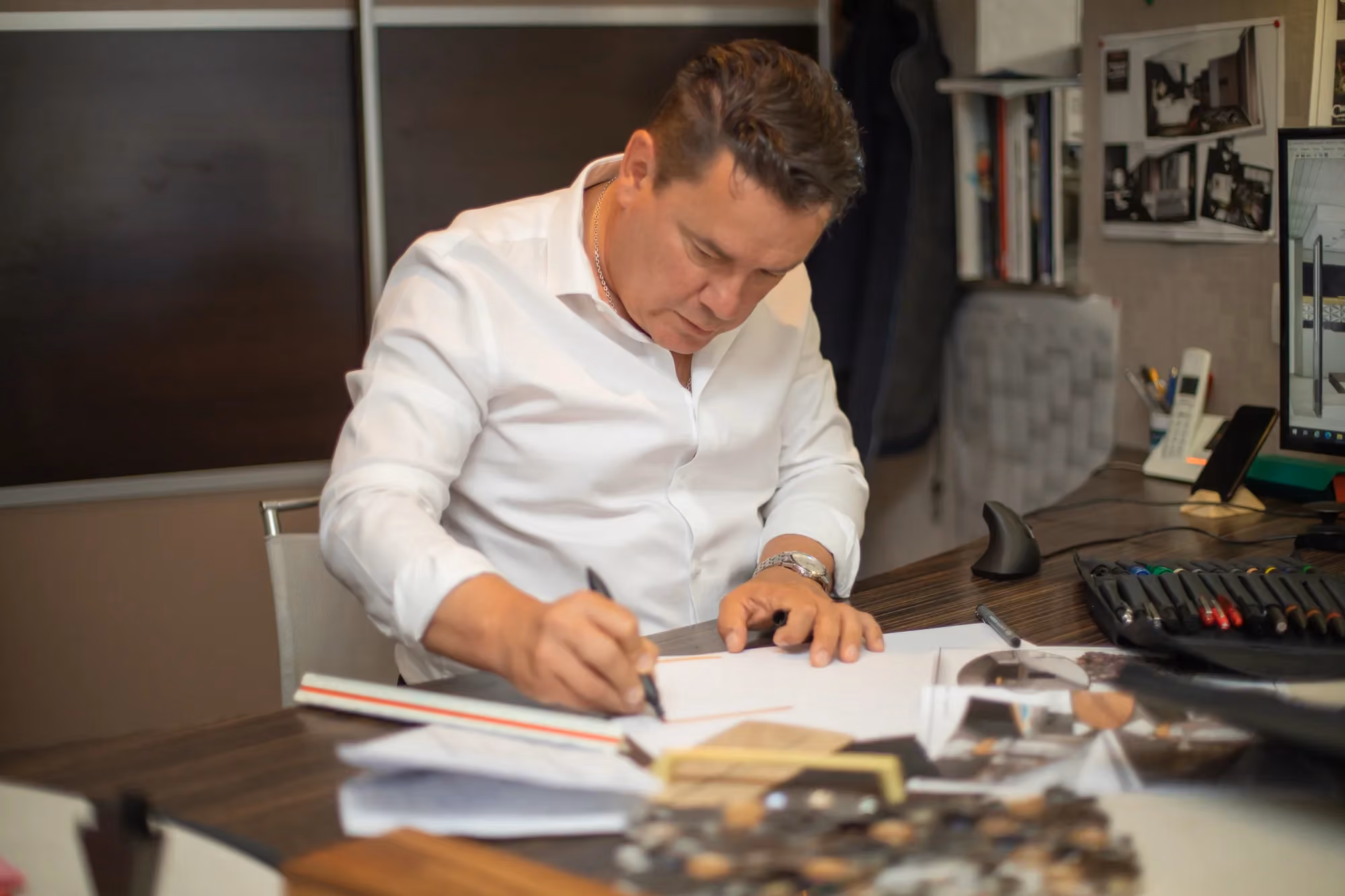 Régis dessine un projet de cuisine sur mesure à son bureau.